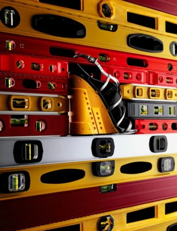 Black and white platform sandal with ankle strap on a background of yellow, red and gray levels, eye-level angle.