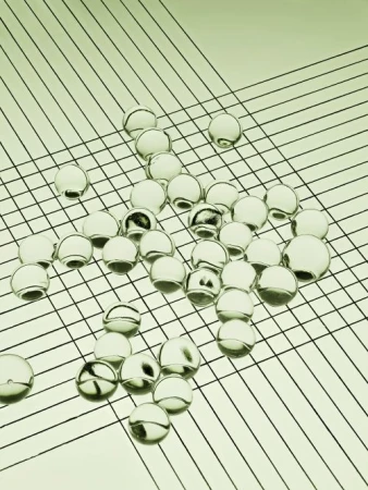 Translucent spheres scattered on a surface with linear pattern creating a geometric composition and minimalist aesthetic, close-up shot.