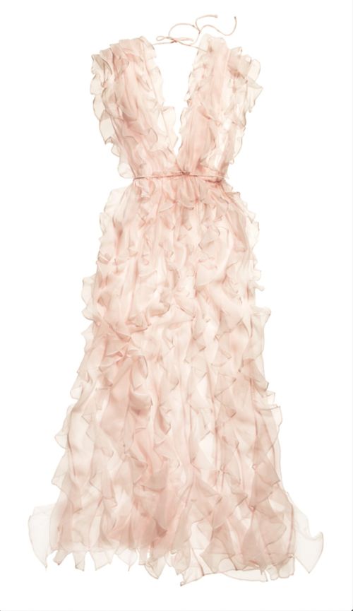 A pale pink dress with ruffles hangs on a hanger against a white backdrop, showcasing its layered design and soft color palette.