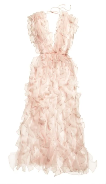 A pale pink dress with ruffles hangs on a hanger against a white backdrop, showcasing its layered design and soft color palette.