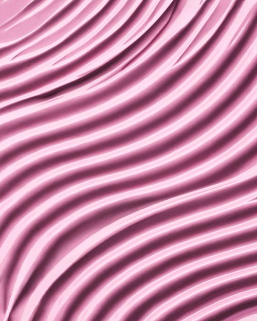 Close-up shot of wavy pink fabric creating a soft, elegant texture and pattern, ideal for backgrounds or abstract visuals.