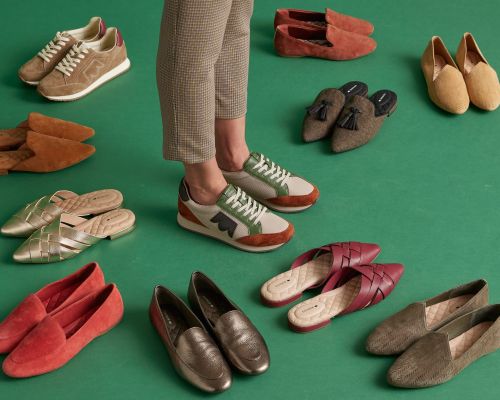 Various styles and colors of footwear, including sneakers and loafers, are displayed on a green background, with a woman's legs visible.