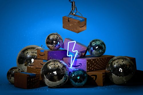 Stack of Amazon boxes and disco balls under a claw game crane arm, lit with a neon lightning bolt against a blue background.