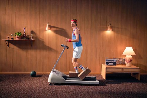 Retro-style image of a man jogging on a vintage treadmill in a wood-paneled room with retro furniture and lighting.