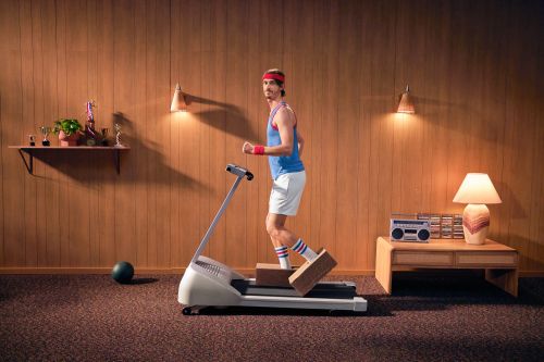 Retro fitness: A man in a vintage workout outfit exercises on a treadmill indoors, creating a nostalgic fitness scene with wood paneling.