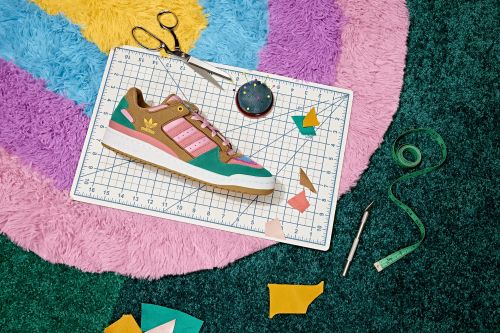 Stylish sneaker, scissors, measuring tape, and crafting tools arranged on a cutting mat, atop a colorful, shaggy carpet.