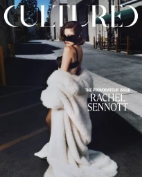 Rachel Sennott wearing a white fur coat and black lingerie in an alleyway by photographer Sam Nixon