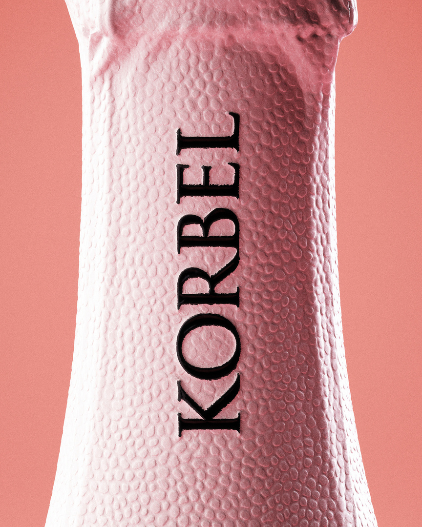Close-up of a pink Korbel champagne bottle neck with the brand name in black lettering against a pale pink background.