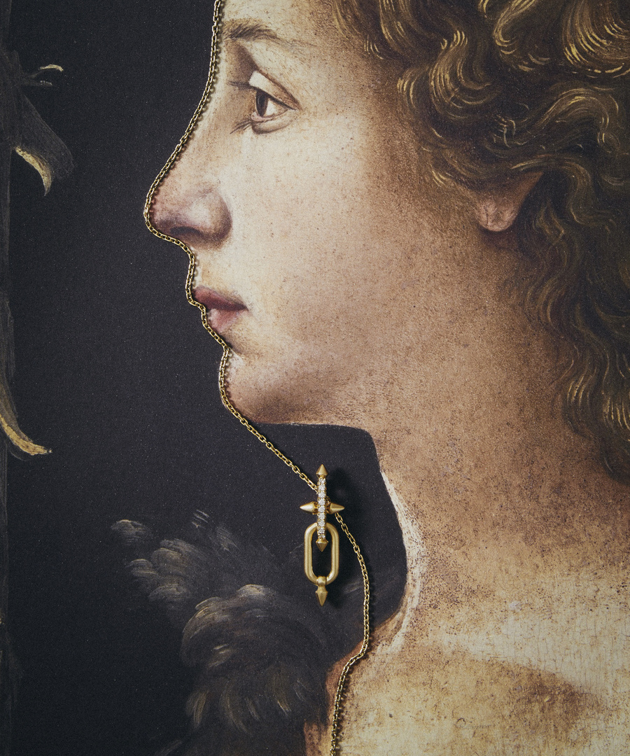 Close-up of a gold necklace with a diamond pendant against a Renaissance-style painting of a woman in profile, fashion editorial.