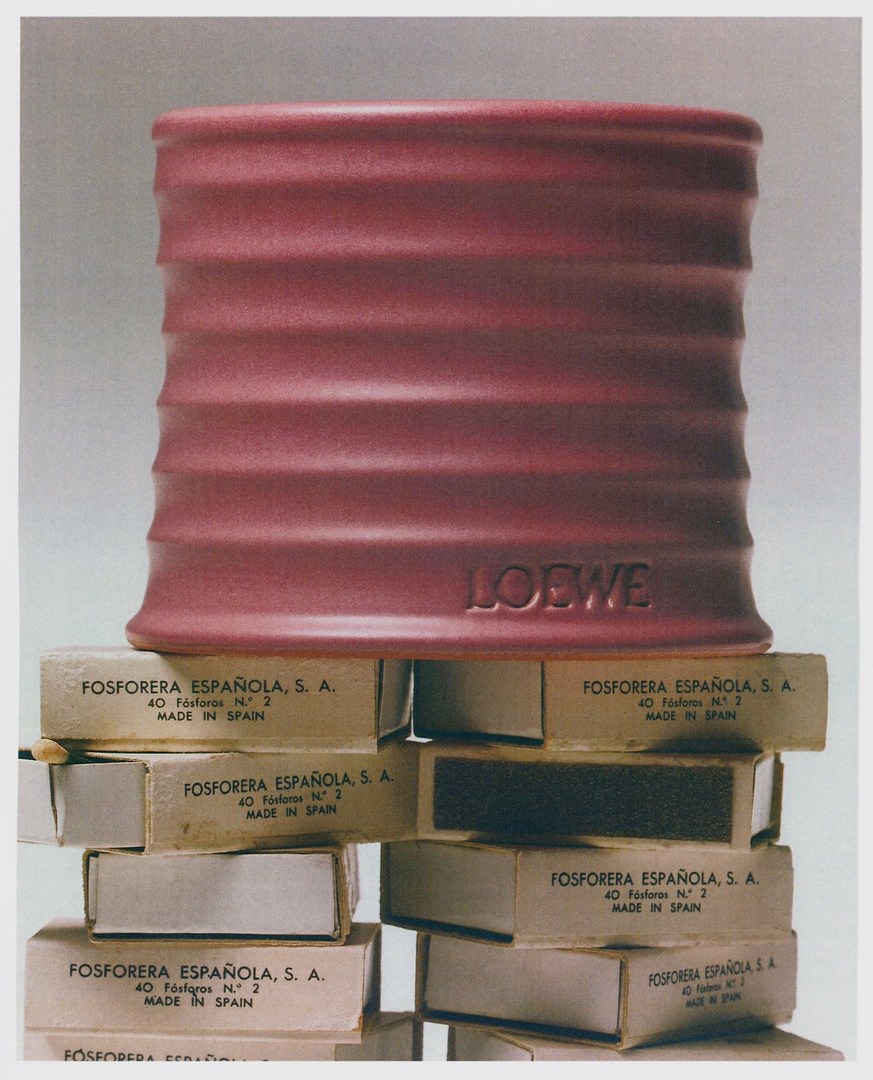 Still life photograph of Loewe stoneware pot on a stack of Spanish matchboxes against a neutral grey studio background.