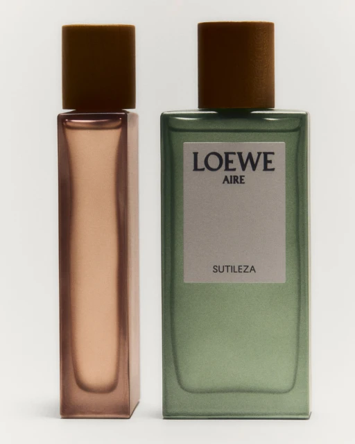 Two Loewe perfume bottles are displayed against a bright white background with a green and brown color palette. The fragrance packaging is minimalist.