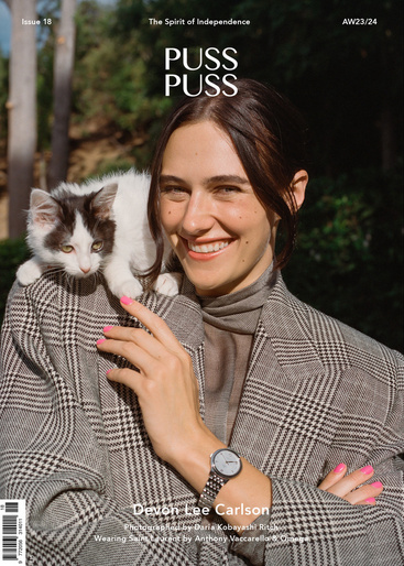 Magazine cover featuring Devon Lee Carlson in a blazer with a kitten on her shoulder, outdoors in a leafy setting.
