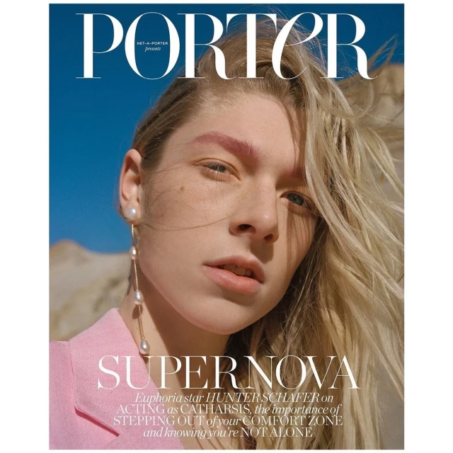 Hunter Schafer graces the cover of Porter magazine, showcasing a close-up shot with blonde hair and pink eyebrows against a blue sky.