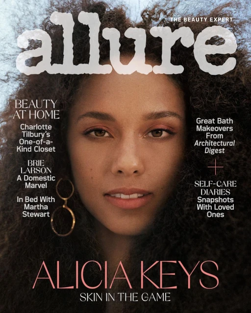 Magazine cover featuring a close-up of Alicia Keys with large Afro hair, against a bright sky backdrop, and Allure logo at the top.