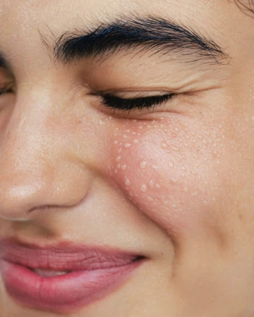 Extreme close-up portrait of a woman with dewy skin, visible droplets, and natural flushed cheeks by Irina Shestakova