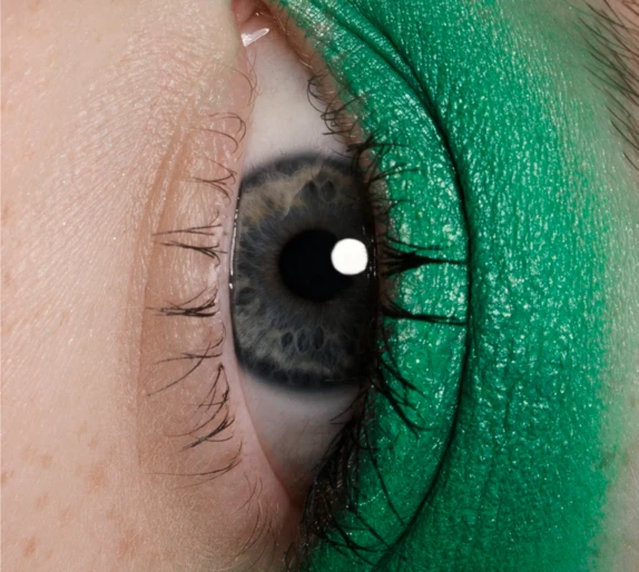 Close-up extreme macro portrait of a blue eye with vibrant green eyeshadow on the eyelid by Irina Shestakova