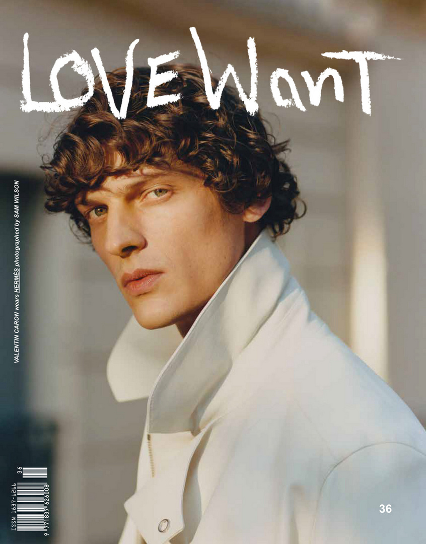 Magazine cover featuring a portrait of a young adult male with curly brown hair wearing a light-colored collared jacket, gazing at the viewer.
