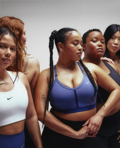 A diverse group of women in athletic wear are posing in front of a white backdrop, showcasing activewear tops and leggings for a sportswear campaign.