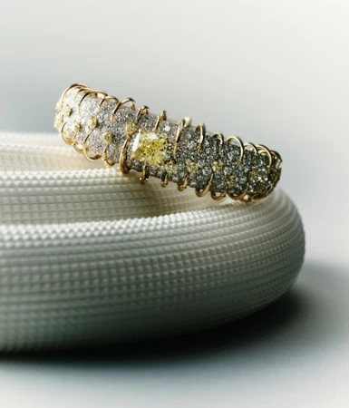 Elegant diamond-encrusted gold bangle bracelet on a textured white surface, highlighted by studio lighting for a luxury jewellery advertisement.
