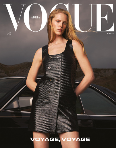 Vogue cover featuring a woman in a black dress, posing next to a black car against a grey sky and landscape background.