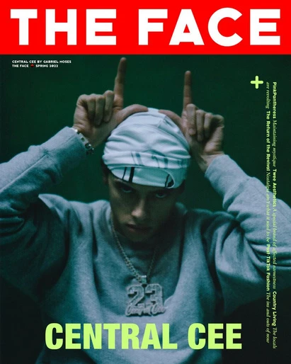 Central Cee on a magazine cover with a dark green background, wearing a white headscarf and a grey sweatshirt, making hand gestures.