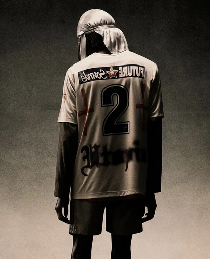 Person from the back wearing a white jersey with the number 2 on it and 'Future Sounds' on the shoulders. Dark background.