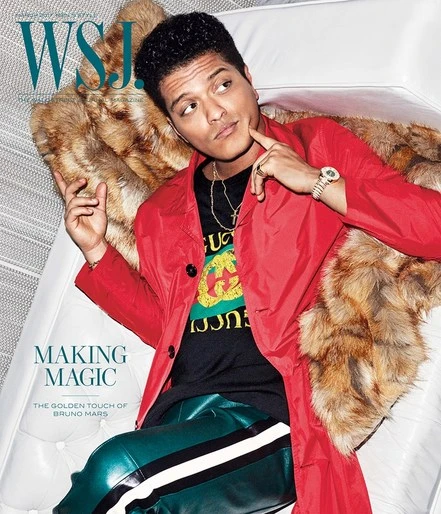 Wall Street Journal magazine cover featuring Bruno Mars in red jacket reclining on white sofa with fur throw, jewelry and patterned shirt.