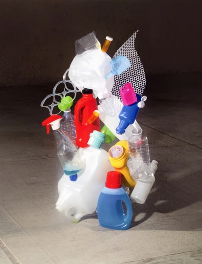 Collection of colorful, recycled plastic bottles, containers, and packaging materials organized into an artful still life composition.