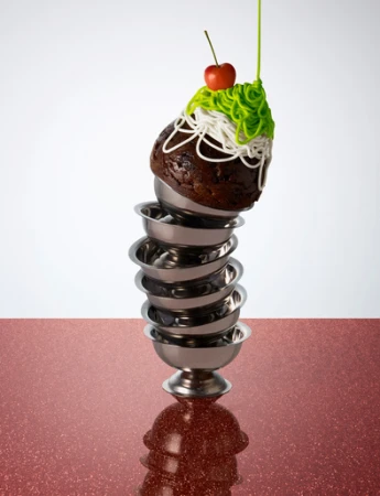 Stacked dessert bowls with chocolate cake, icing, cherry on top, set against a red and white background for food photography.