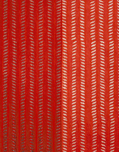An abstract textile design featuring vertical lines of small white and red pattern elements creating a textured and vibrant visual.