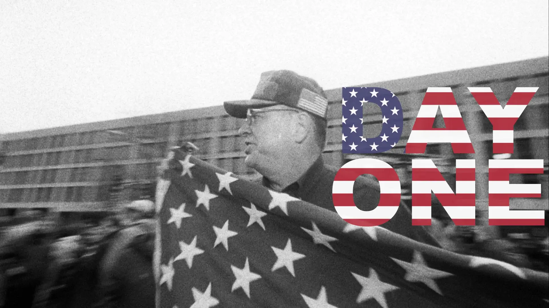 Black and white image of a man holding a US flag with the text 'Day One' overlayed, evoking a sense of American patriotism and history.