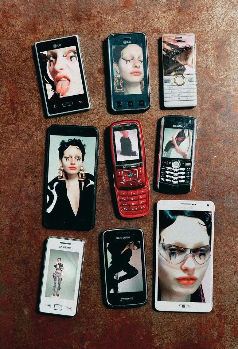 Nine vintage cell phones displayed on a textured brown surface show different photos of a model with avant-garde makeup.