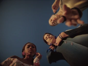 Low angle worm's-eye view of three young women looking down against a clear blue sky by artist Mashie.