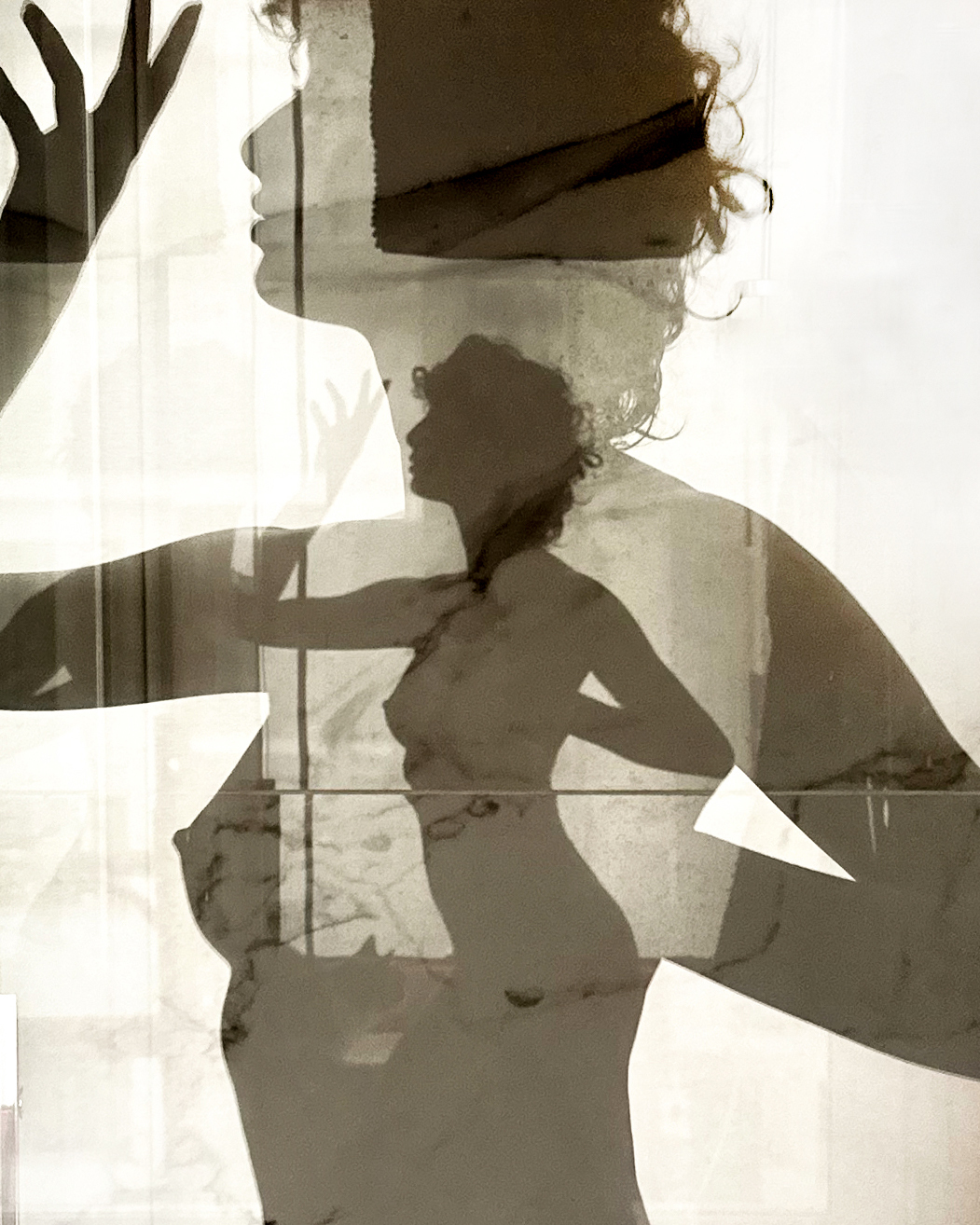Monochromatic art photography featuring the layered silhouette of a woman against a textured window with geometric white shapes.