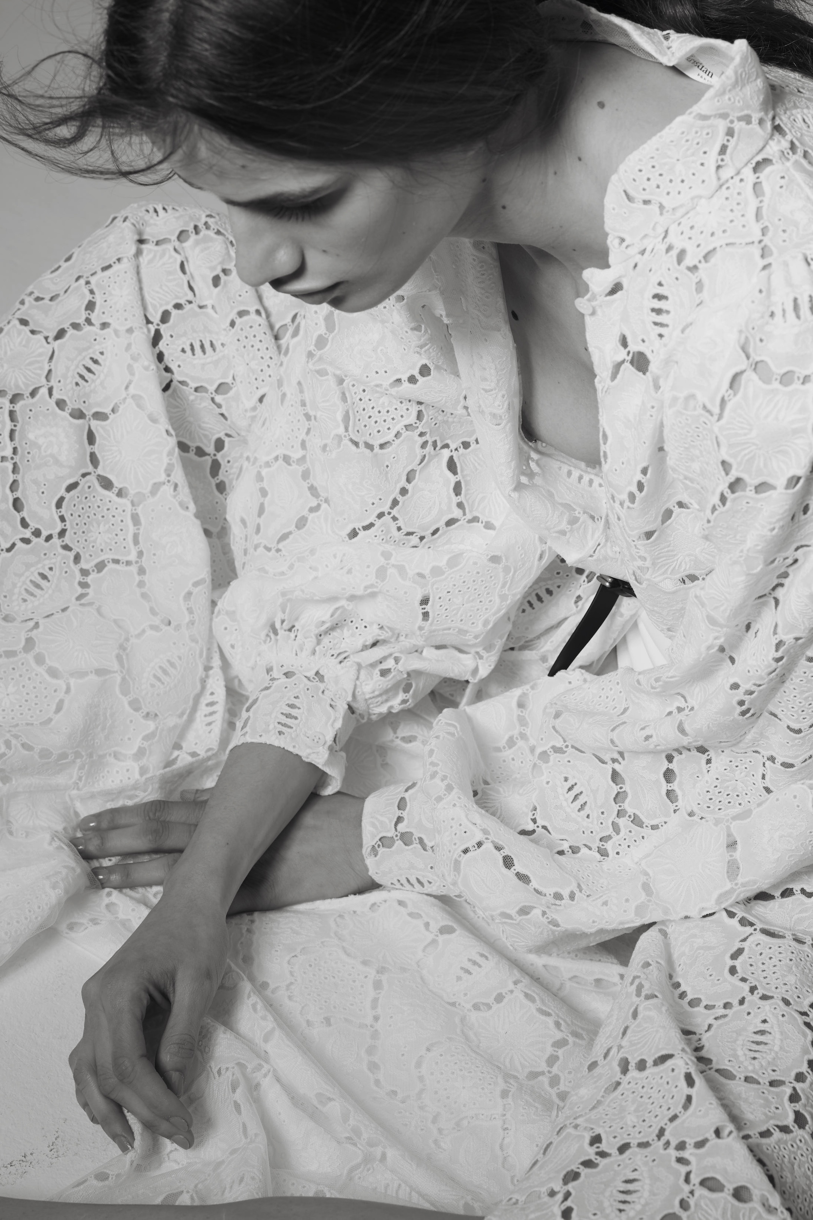 Close-up portrait of a woman in a textured white lace dress with puffed sleeves photographed by Cecilia Duarte.