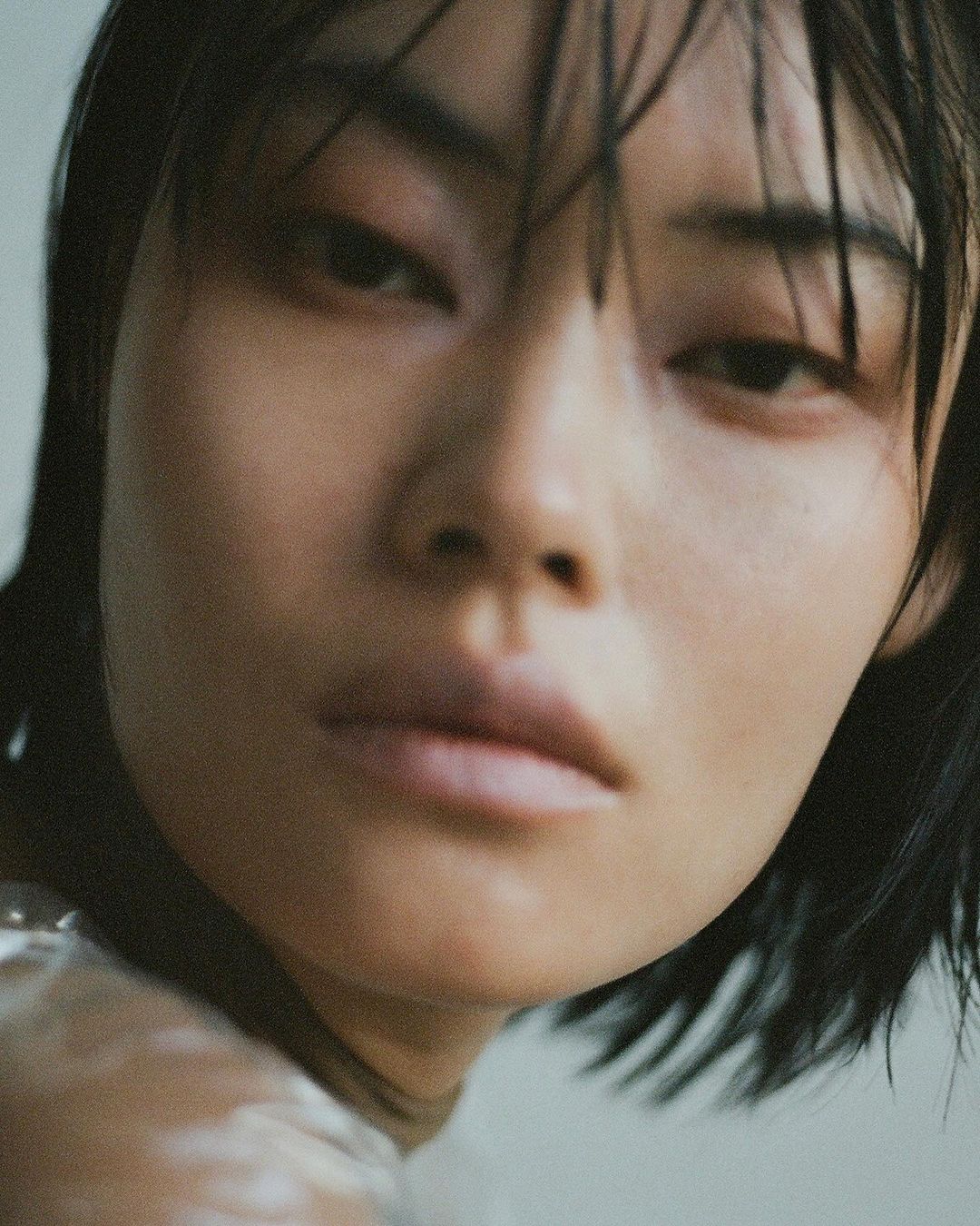 Close-up portrait of an adult woman with short, dark hair and light skin tone, looking directly at the camera with neutral facial expression.