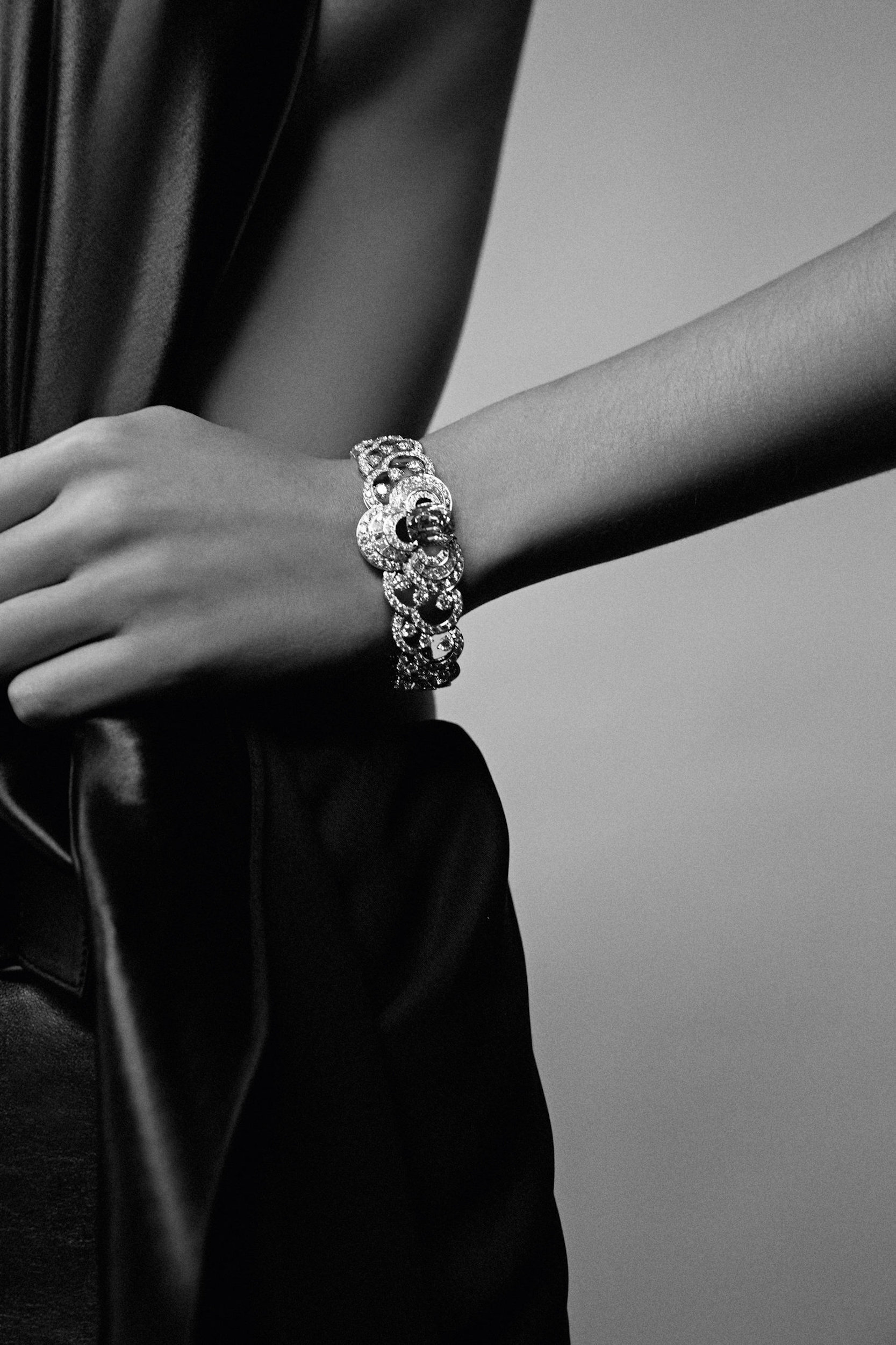 Close-up monochrome portrait of a person wearing an ornate diamond bracelet on their wrist, photographed by Cecilia Duarte