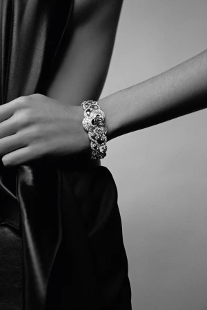 Close-up monochrome portrait of a person wearing an ornate diamond bracelet on their wrist, photographed by Cecilia Duarte