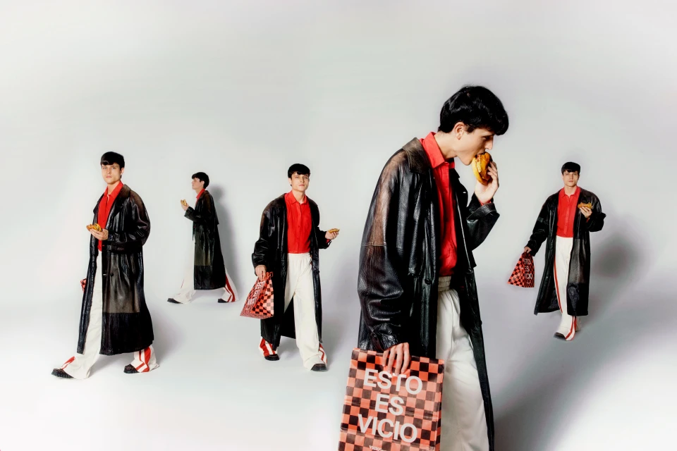 Multiple instances of a young man wearing a black trench coat over a red collared shirt and white pants, posing with food and a checkered bag.