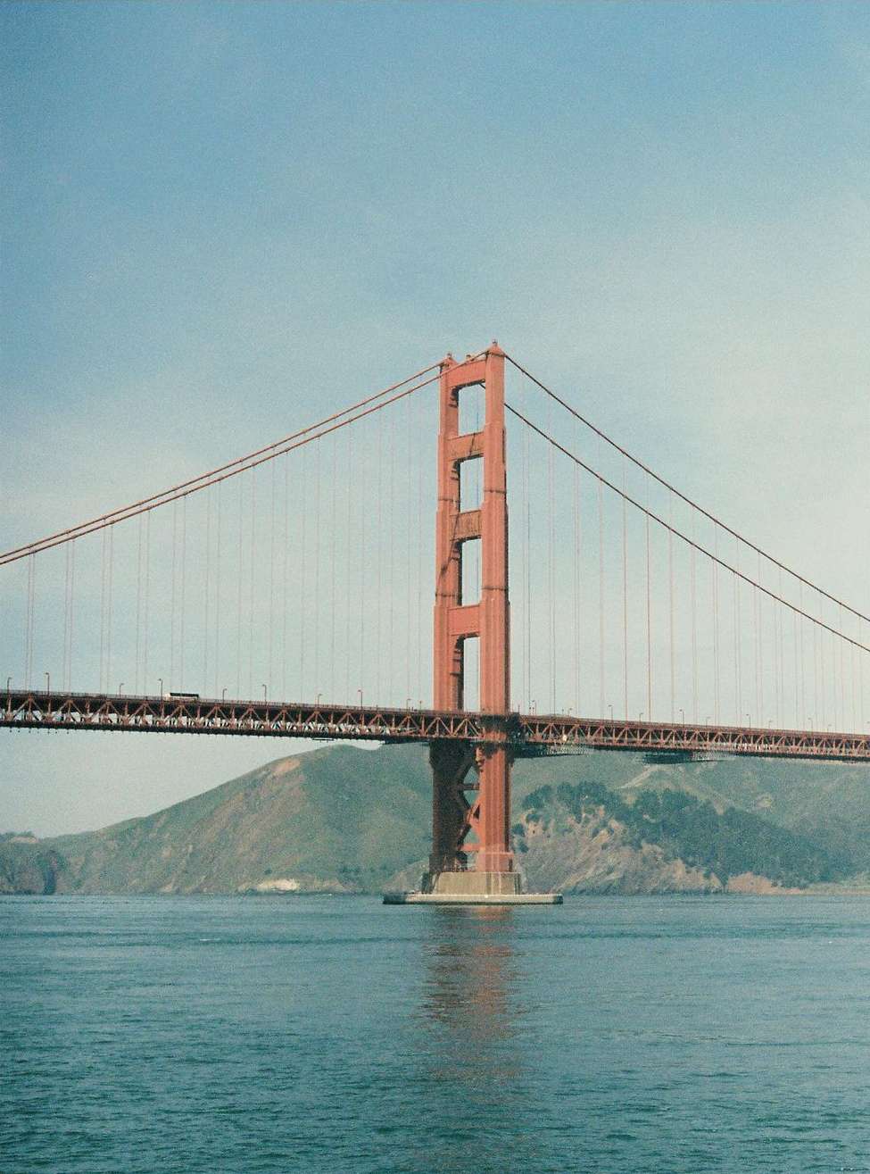 View of the Golden Gate Bridge in San Francisco, California, with blue sky and water on a sunny day, capturing its iconic architecture.