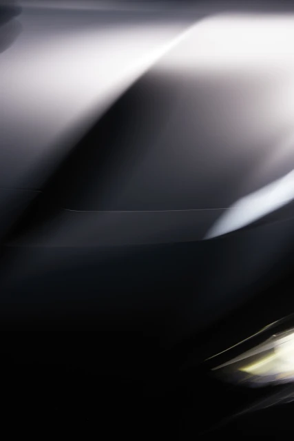 Abstract image featuring blurred lights and dark contrasts, creating a sense of movement and mystery in a vertical format.