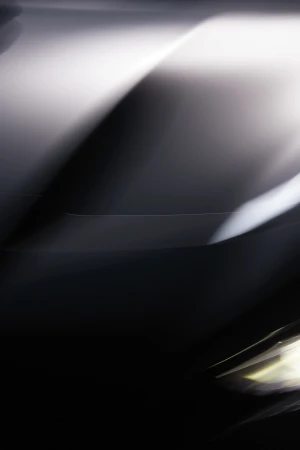 Abstract image featuring blurred lights and dark contrasts, creating a sense of movement and mystery in a vertical format.