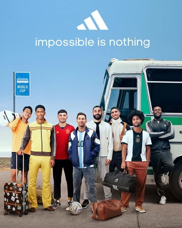 Adidas campaign featuring soccer players in front of a bus with soccer balls and luggage on a clear day outdoors.