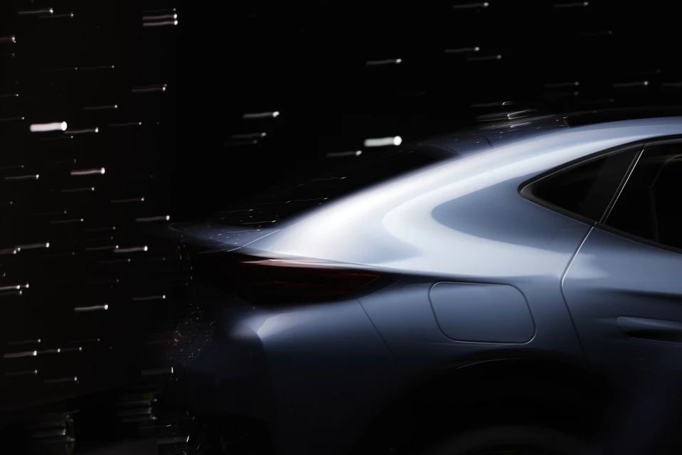 Sleek blue car in motion with motion blur and dark background, showcasing automotive design and speed, elegant lines.
