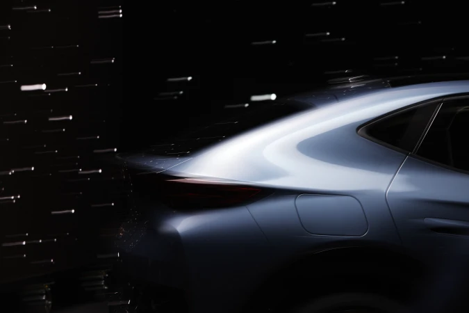 Sleek blue car in motion with motion blur and dark background, showcasing automotive design and speed, elegant lines.