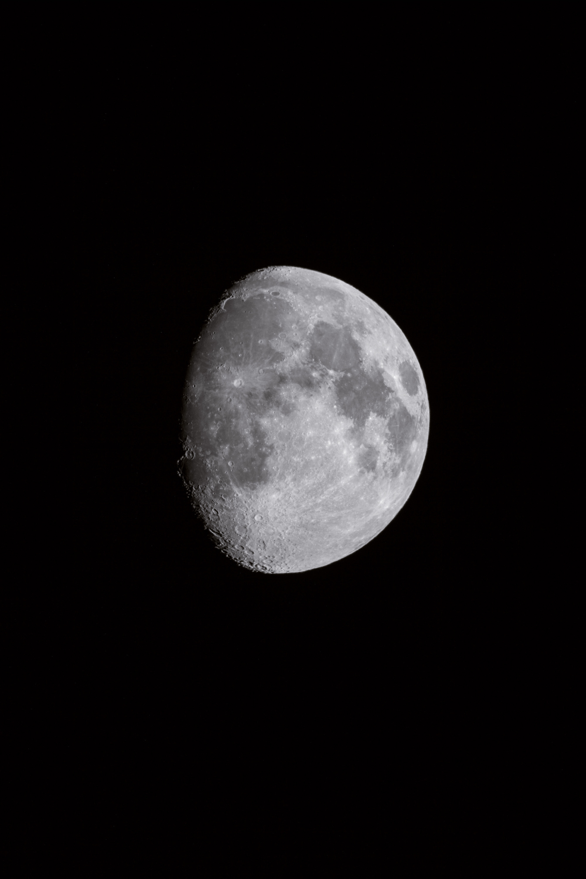 Detailed photograph of the moon with craters against a black sky, showcasing its surface texture and lunar details.