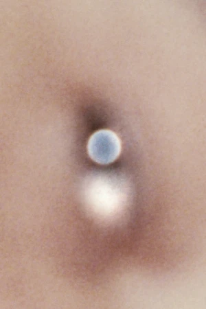 Close-up of a person's pierced navel. A silver ball is visible where a piercing would be located, with the person's skin in the background.