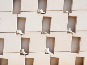 White boots and heels displayed in architectural wall niches by photographer Rita Puig-serra Costa