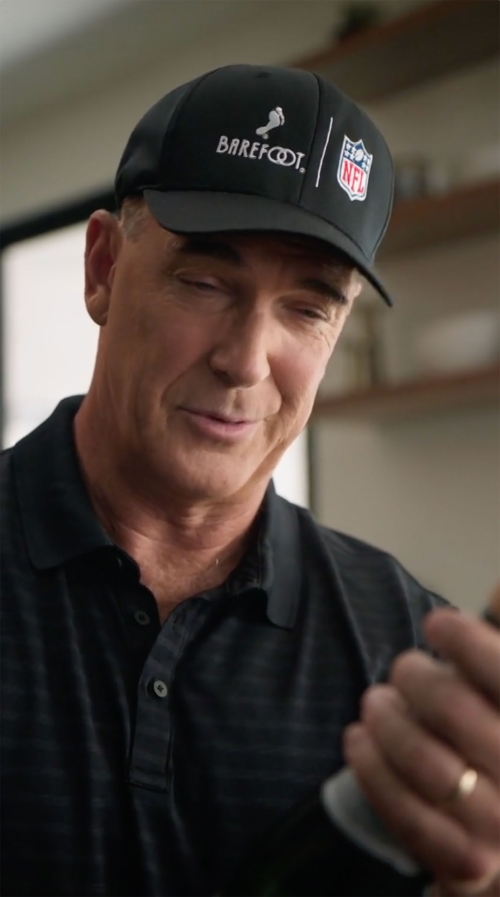 Adult male wearing a Barefoot-branded NFL baseball cap smiles in an interior setting. The focus is on his face and upper torso.