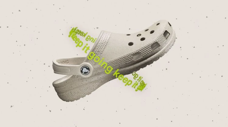 Beige Croc sandal floating against a speckled background with green text accents, showcasing casual footwear.